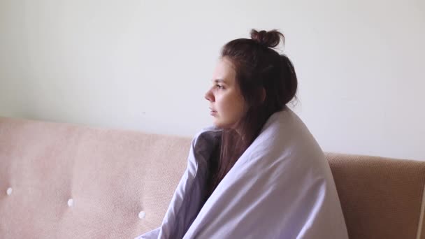 Nemocná mladá žena sedí doma s tekoucím nosem. - Záběry, video
