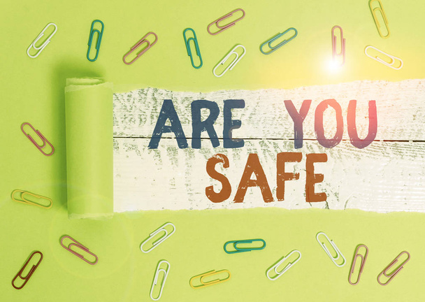 Text sign showing Are You Safe. Conceptual photo Free from danger Not anticipating any Harm Hurt physically Paper clip and torn cardboard placed above a wooden classic table backdrop. - Photo, Image