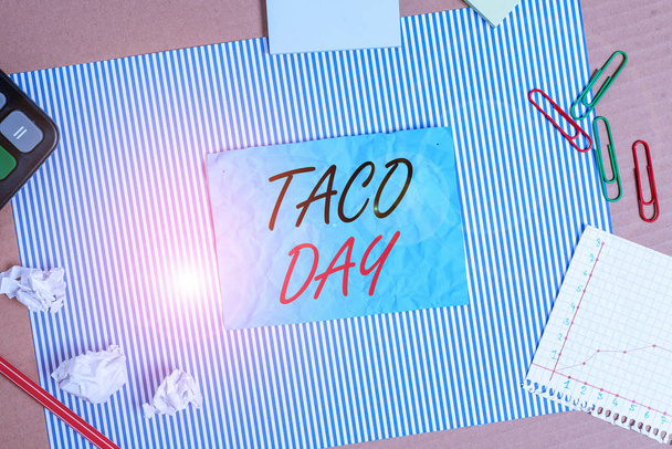 Handschrift Text Taco-Tag. Konzept bedeutet feierlichen Tag, der zum Konsum von Tacos in der uns gestreiften Pappe Notizbuch fördert Karton Bürostudie liefert Diagrammpapier. - Foto, Bild