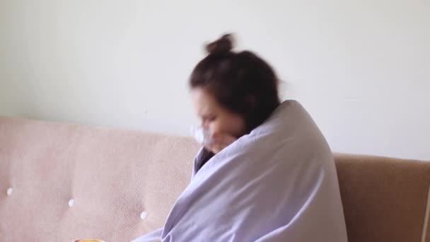 Doente jovem mulher sentada em casa com um nariz escorrendo e ela espirra
 - Filmagem, Vídeo