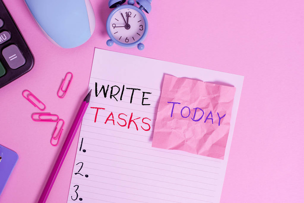 Text sign showing Write Tasks. Conceptual photo assigned piece of work often to be finished within certain time Calculator clips clock clipboard mouse sheet note pencil color background. - Photo, Image