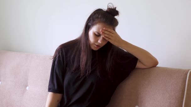 Mujer joven enferma sentada en casa con dolor de cabeza severo
 - Metraje, vídeo