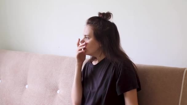 A beteg fiatal nő otthon ül torokfájással és köhögéssel.. - Felvétel, videó