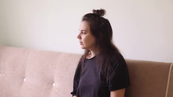 Nemocná mladá žena sedí doma s tekoucím nosem a kýchá - Záběry, video