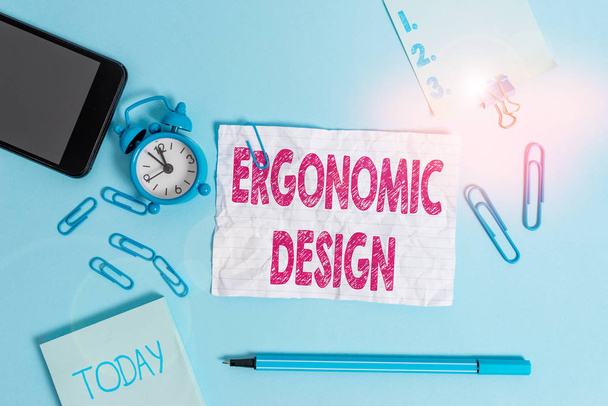 Text sign showing Ergonomic Design. Conceptual photo fitting or designing a workplace to the user s is needs Alarm clock clips notepad smartphone rubber band marker colored background. - Photo, Image