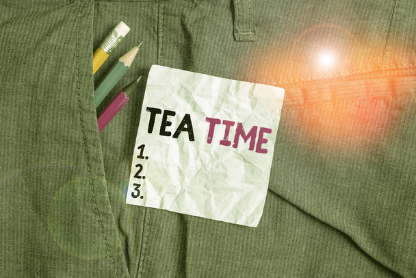 Word writing text Tea Time. Business concept for the time in the afternoon when some showing eat a small meal Writing equipment and blue note paper inside pocket of man work trousers. - Photo, Image