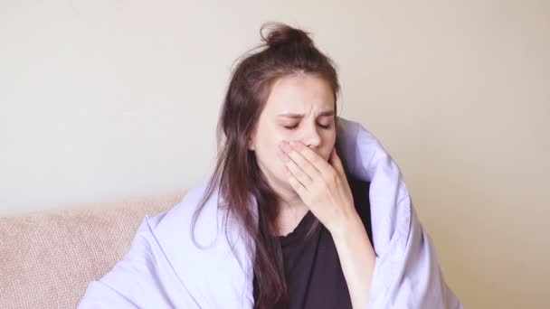 Mujer joven enferma se sienta en casa con dolor de garganta y tos
. - Imágenes, Vídeo