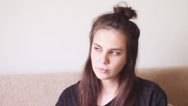 Mujer joven enferma sentada en casa con una nariz mocosa y estornuda
 - Imágenes, Vídeo