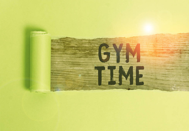 Szóírás szöveg Gym Time. Üzleti koncepció a fából készült klasszikus asztal fölött középen széttépett fitness karton készítésének megkezdésére irányuló motivációra. - Fotó, kép
