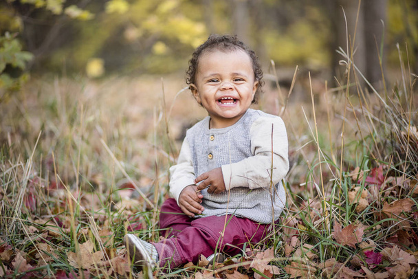 Kültéri portré egy gyönyörű mosolygós kevert fajú kisfiúról. Imádnivaló gyermek, nagyon boldog arckifejezéssel az aranyos arcán. - Fotó, kép