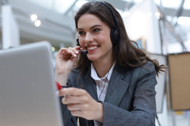 Woman customer support operator with headset and smiling. - Φωτογραφία, εικόνα