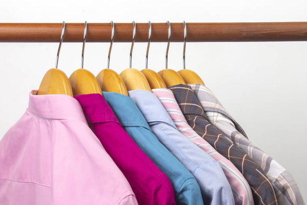 Die klassischen Hemden für das Frauenbüro hängen an einem Kleiderbügel. - Foto, Bild