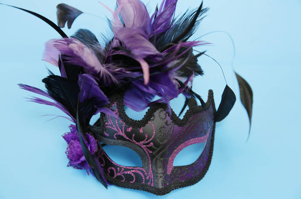 青い背景に羽が隔離されたカーニバルのベジタリアンマスク。休日と仮面舞踏会のコンセプト. - 写真・画像