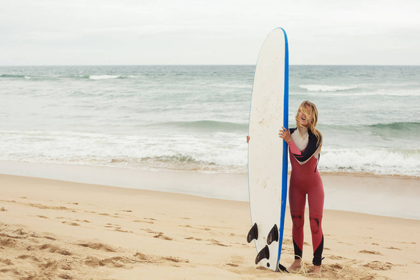 Smiling female surfer with surf longboard board near ocean - Foto, Imagen