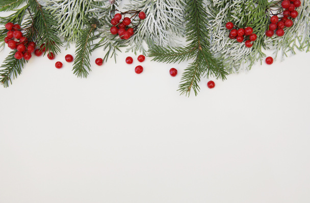 Beyaz zemin üzerinde kar ve kırmızı böğürtlenlerle süslenmiş Noel ağacı dalı metin ve görüntü için kopyalama alanı var. Noel ve Yeni Yıl konsepti. Kompozisyon, Desen, arkaplan, kart - Fotoğraf, Görsel