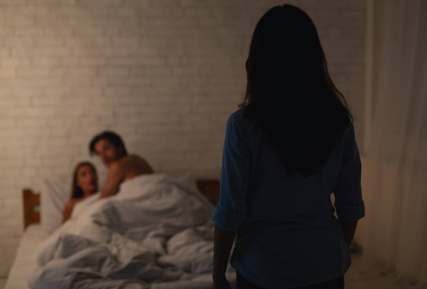 Bir kadın, erkek arkadaşını başka bir kızla yatak odasında aldatırken yakaladı. - Fotoğraf, Görsel