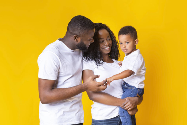 Νεαροί Αφροαμερικανοί γονείς δένονται με τον μικρό τους γιο. - Φωτογραφία, εικόνα