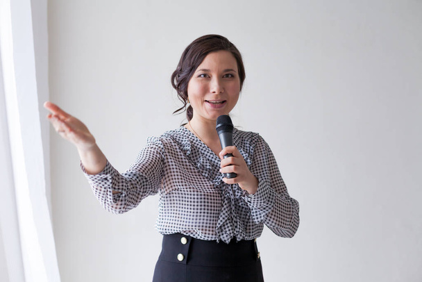 Gyönyörű, divatos ázsiai nő mikrofonnal az előadáson - Fotó, kép