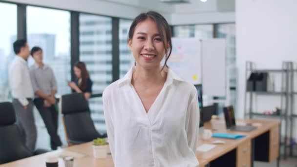Portrait of successful beautiful executive businesswoman smart casual wear looking at camera and smile, arms crossed in modern office workplace. Young Asia lady standing in contemporary meeting room. - Filmati, video