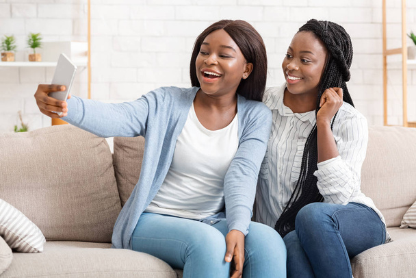 Dwie czarne koleżanki robią sobie selfie, bawią się w domu - Zdjęcie, obraz