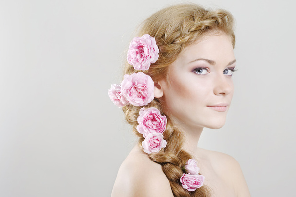 Woman with with braids and roses in hair - Foto, afbeelding