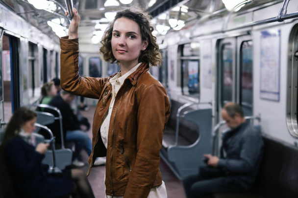 Young female standing in metro train - Фото, зображення