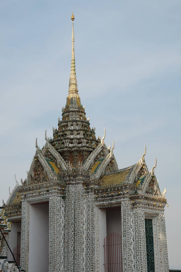 Wspaniały buddyjski budynek z białymi murami i wysoką iglicą. - Zdjęcie, obraz