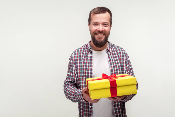 Portrait of happy satisfied bearded man holding gift box and smi - Foto, Bild