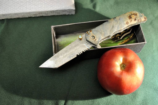 Apple organic fruit gourmet healthy product folding knife wood handles green background - Photo, Image