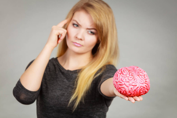 Woman thinking and holding fake brain - Photo, Image