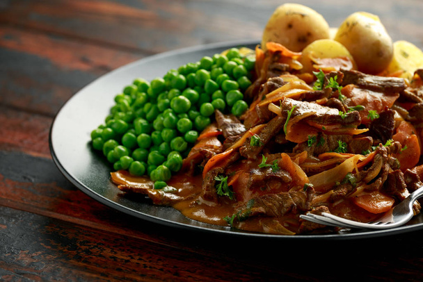 Classic beef stroganoff servei with boiled baby potato and sweet peas - Photo, Image