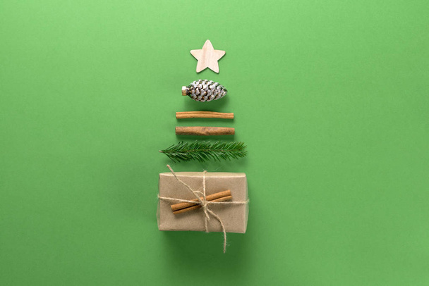 Christmas composition. Creative christmas background. Christmas decorations and gifts in the form of a Christmas tree against a green background. Flat lay, top view, copy space. - Fotografie, Obrázek