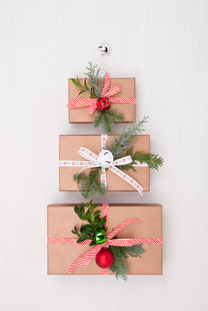 Christmas composition. Gifts, fir tree branches, jingle bells on - 写真・画像