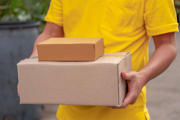 Жовтий чоловік доставки несе посилки
. - Фото, зображення