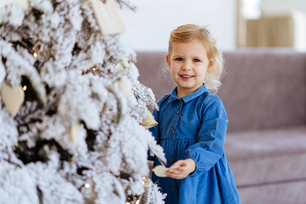 Little girl with Christmas gifts near a Christmas tree - Φωτογραφία, εικόνα