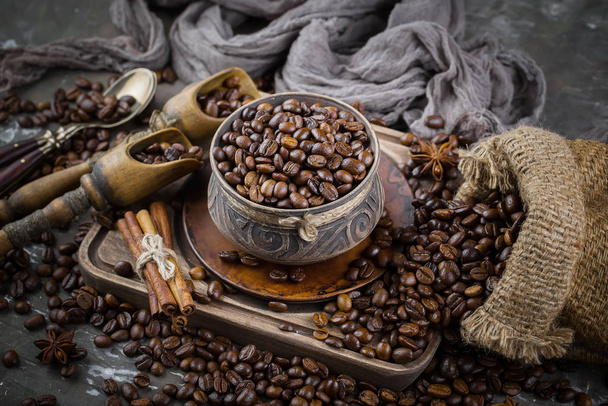 Kaffee in einer Tasse auf einem Hintergrund aus Kaffeebohnen, auf einem alten Hintergrund. - Foto, Bild
