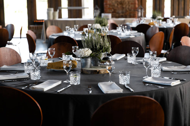 東ヨーロッパの誕生日パーティー中に白いホールで丸いテーブルで提供される食べ物バルト・リガ・ラトビア-田舎風の木造アンバーホール-カナッペ、軽食、軽食 - 写真・画像