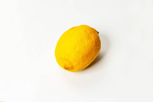 Faded stale lemon on a white background close up. - Fotografie, Obrázek