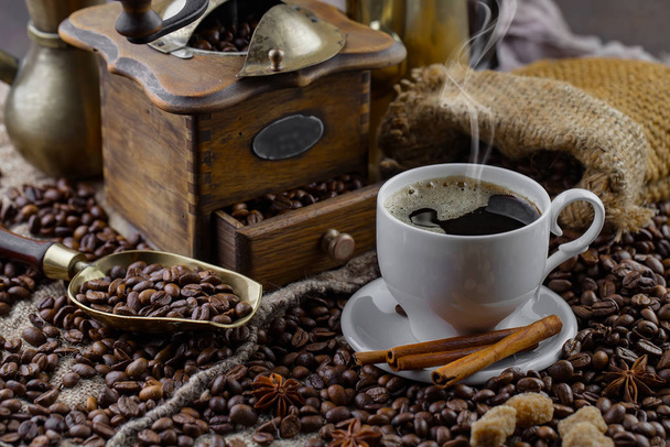Coffee in a cup on a background of coffee beans, on an old background. - Photo, Image