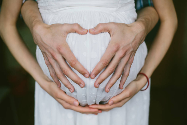 Hands of Pregnant Mother and father standing holding belly, young family concept - Фото, зображення