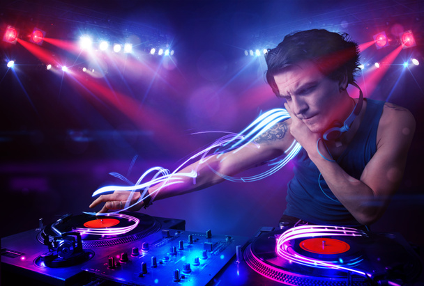 Disco jockey tocando música com efeitos de feixe de luz no palco
 - Foto, Imagem