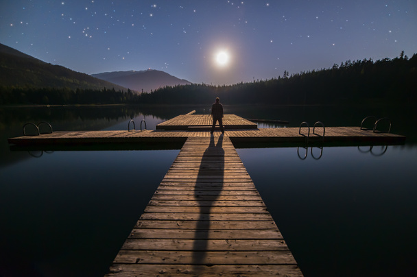 Hombre mirando a la luna en muelle en Whistler
 - Foto, imagen