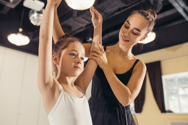 young trainer coach of the ballet school helps young ballerinas - Fotografie, Obrázek