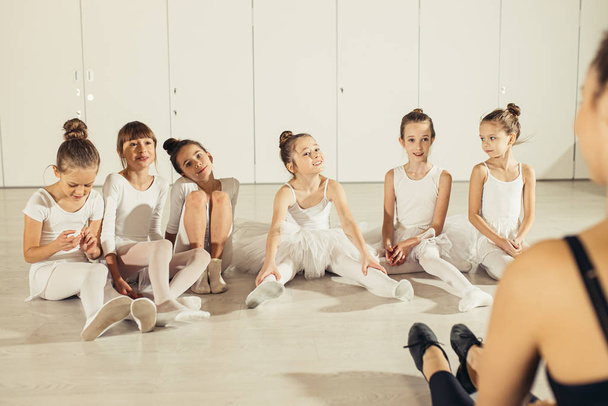 attentive young ballerinas listen to teacher in studio - Fotoğraf, Görsel