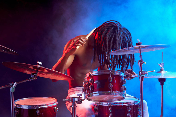 portrait of professional drummer man isolated in smoky space - Photo, Image