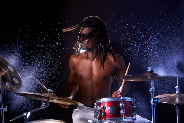 Drummer black male musician hitting on wet drum cymbal and water splashing in slow motion - Fotografie, Obrázek