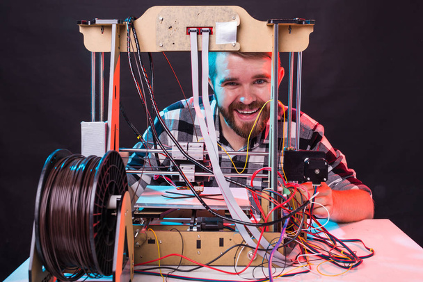 Hombre estudiante hace el artículo en la impresora 3D
 - Foto, Imagen
