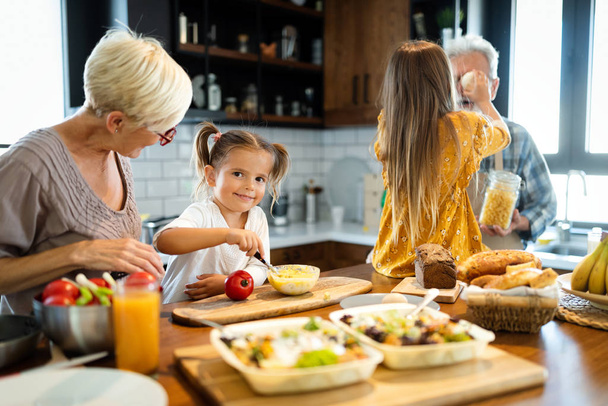 Mosolygó boldog nagyapa segít a gyerekeknek főzni a konyhában - Fotó, kép