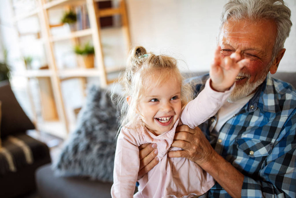 Happy grandparent playing and having fun with their granddaughter - 写真・画像