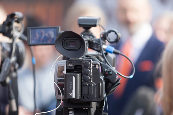 Filmen nieuws of persconferentie met een videocamera - Foto, afbeelding